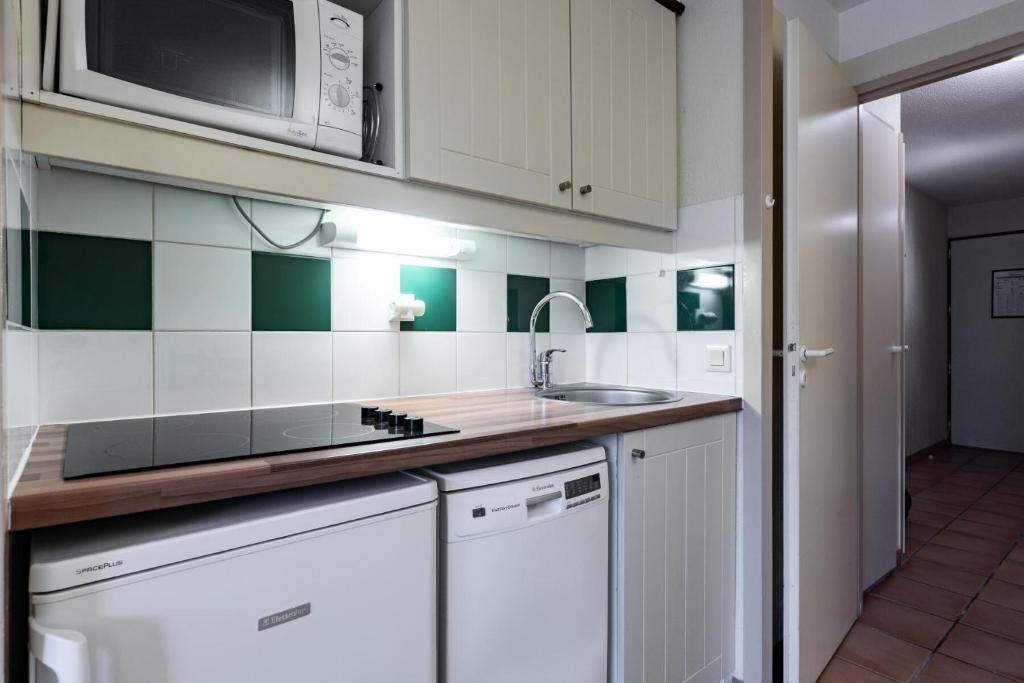 a kitchen with a sink and a microwave at Le Domaine du Golf de Pinsolle - maeva Home - Appartement 2 pièces 6 person 574 in Soustons