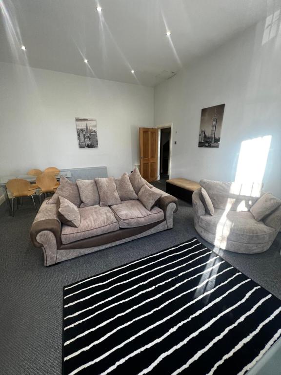 a living room with a couch and a table at No 3 - LARGE 1 BED NEAR SEFTON PARK AND LARK LANE in Liverpool