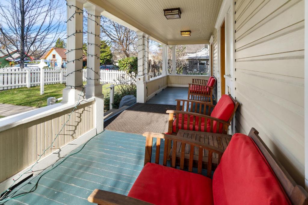 een veranda met rode stoelen op een huis bij Pioneer Vacation Rentals - Pioneer South downtown Ashland in Ashland