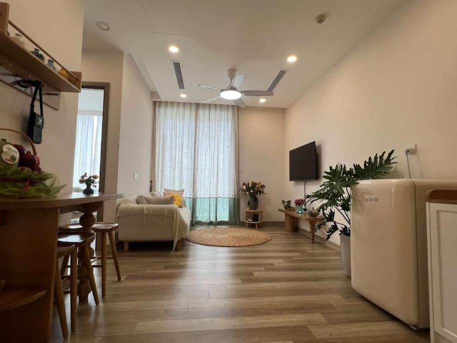 uma sala de estar com um sofá e um frigorífico em Fami-homestay-ecopark-Căn hộ 1PN 2 giường em Kim Quan