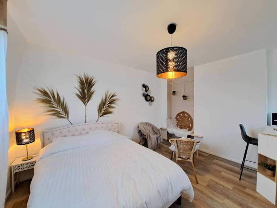 ランスにあるFaro, vue sur la Cathédraleの白いベッドと鉢植えの植物が備わるベッドルーム1室