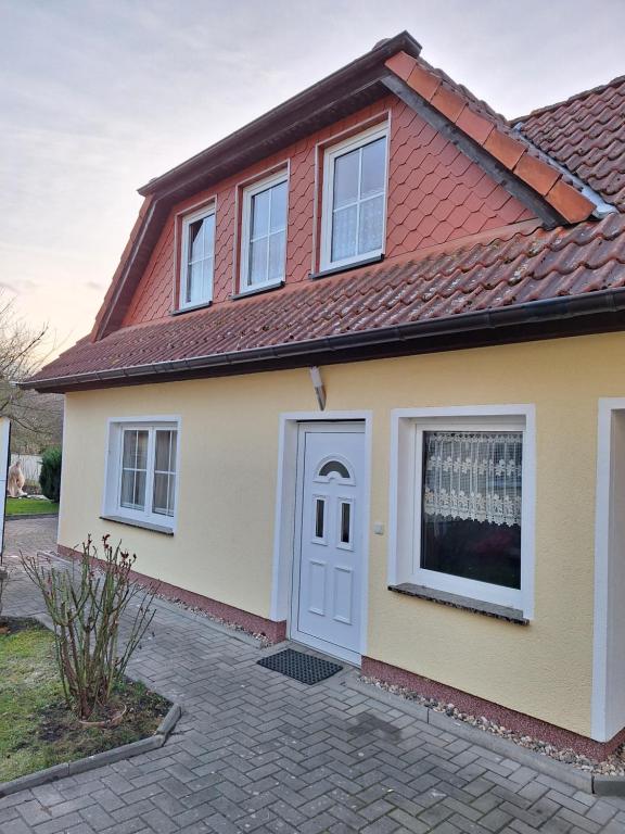 uma casa com uma porta branca e um telhado vermelho em Emma em Greifswald