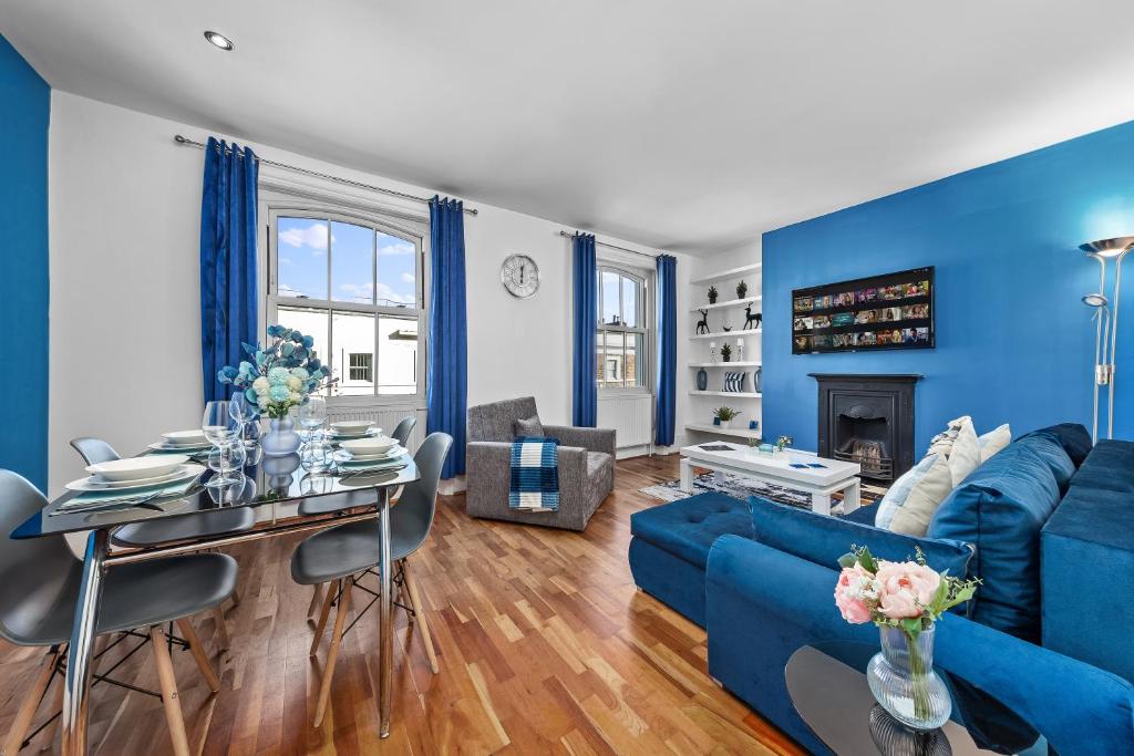 a living room with blue walls and a blue couch at Blue Themed Luxury 1 Bedroom Balcony Flat, With Double Sofa Bed and Fast Wifi! Accommodates up to 6 Guests! Hyde Park! in London