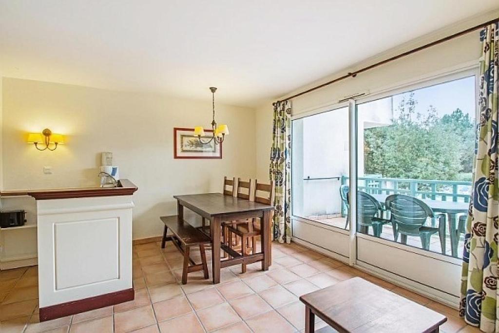 d'un salon avec une table et un balcon. dans l'établissement Le Domaine du Golf de Pinsolle - maeva Home - Appartement 2 pièces 6 personnes - Confort MAE-9354, à Soustons