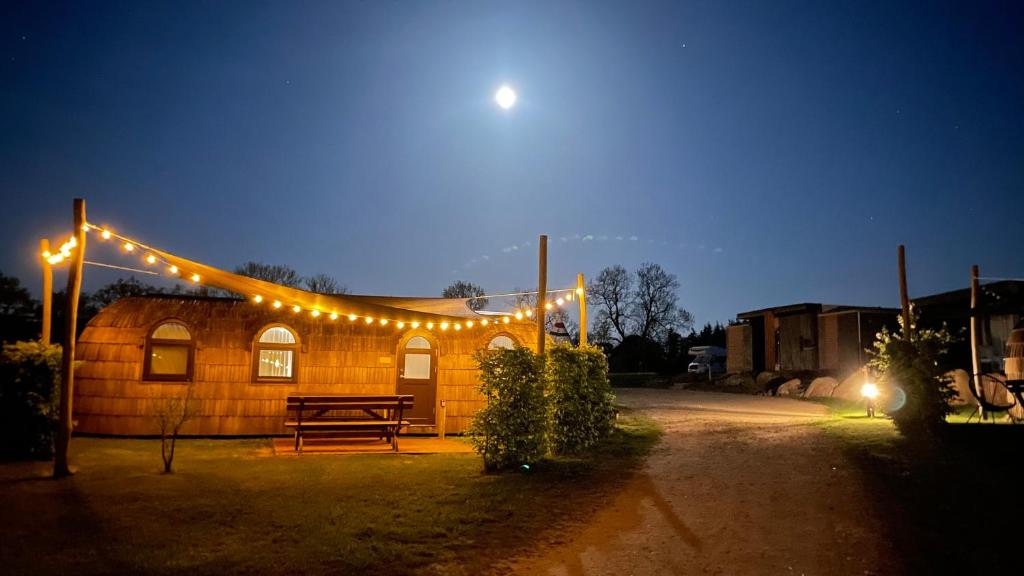 a wooden building with lights on it at night at Tiny IglooKarlsson in Belau