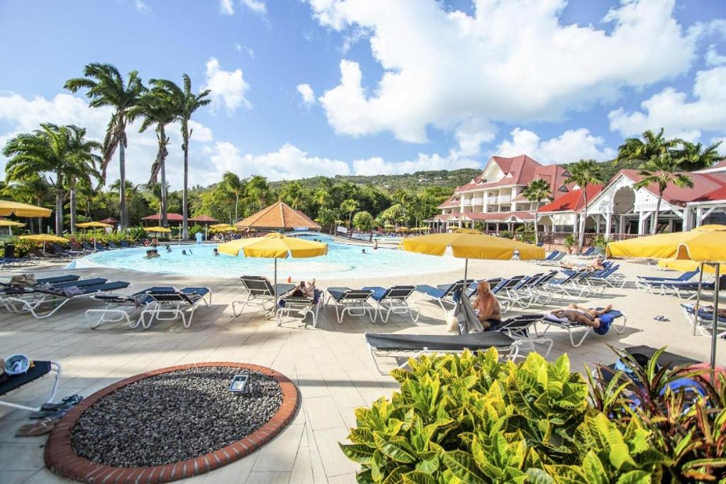 a pool at a resort with chairs and umbrellas at Village Sainte Luce, Martinique - maeva Home - Studio 3 personnes - Prestige 704 in Sainte-Luce