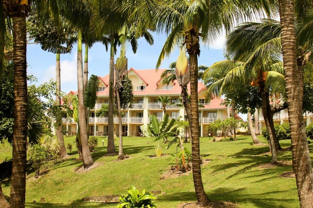 a resort with palm trees in front of it at Village Sainte Luce, Martinique - maeva Home - Studio 3 personnes - Prestige 704 in Sainte-Luce