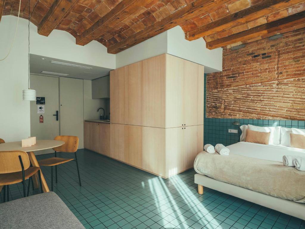 um quarto com uma cama e uma mesa num quarto em Boutique Apartments 23 Barcelona em Barcelona