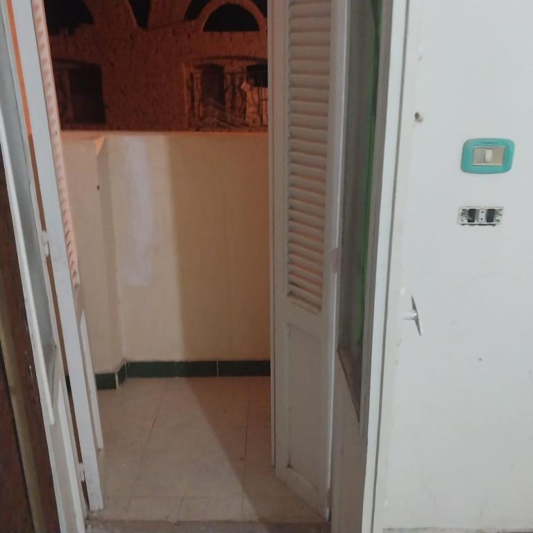 korytarz z białymi drzwiami i podłogą wyłożoną kafelkami w obiekcie Adel Hotel w mieście Abu Simbel