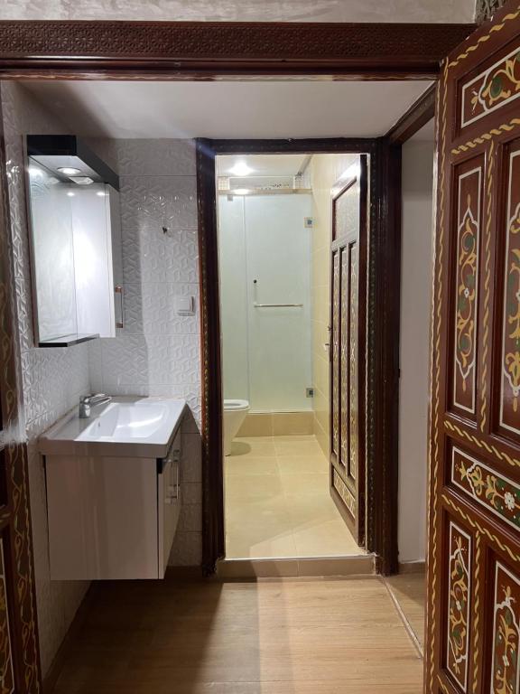 uma casa de banho com um lavatório, um espelho e uma porta em Riad el wazania em Rabat