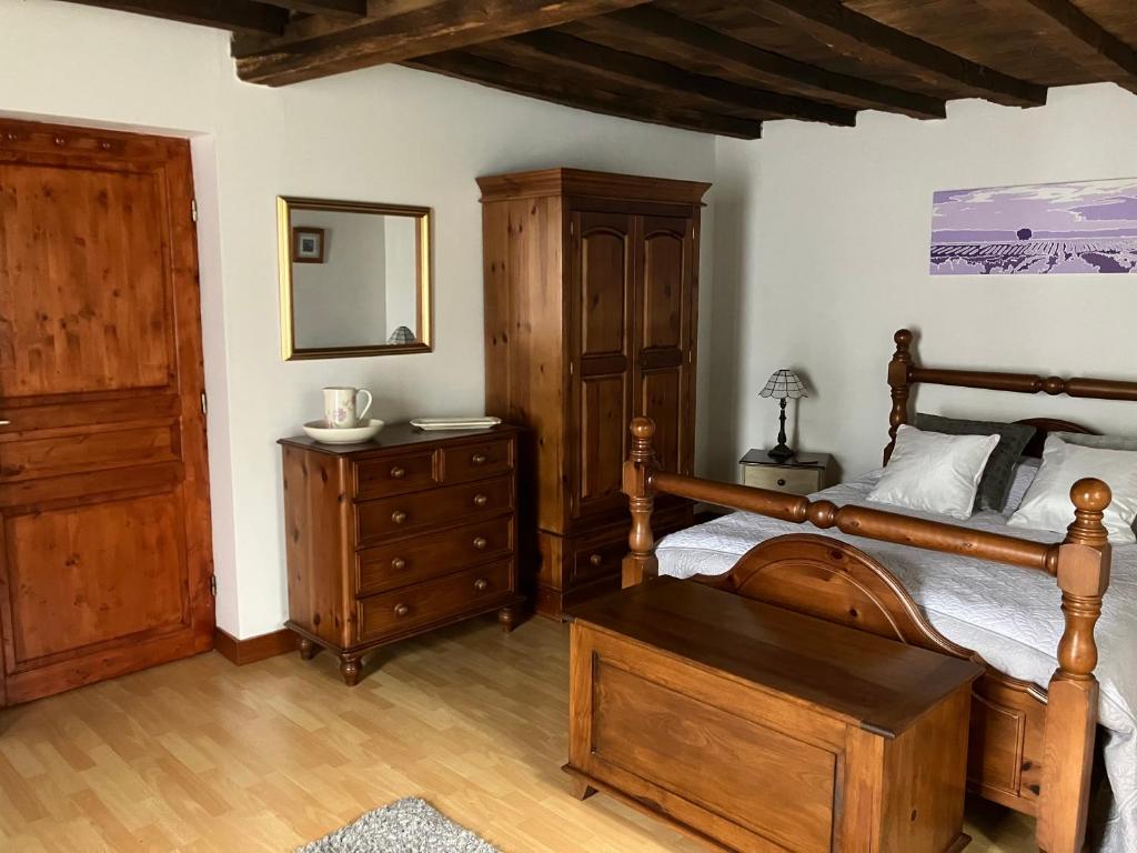 1 dormitorio con cama de madera y tocador de madera en Puyleger, en Saint-Privat-des-Prés