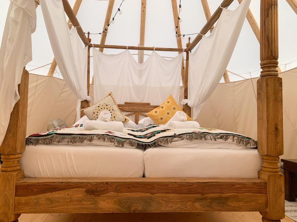 een bed met een luifel met een boek erop bij Tipi Blackfoot in Belau
