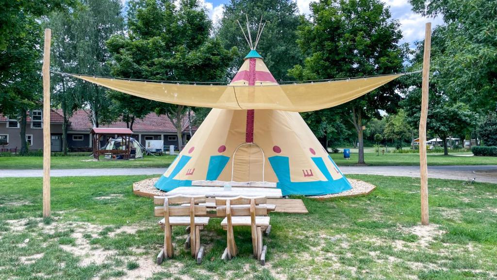 une tente de jeux avec deux chaises devant elle dans l'établissement Tipi Missouri, à Falkenberg