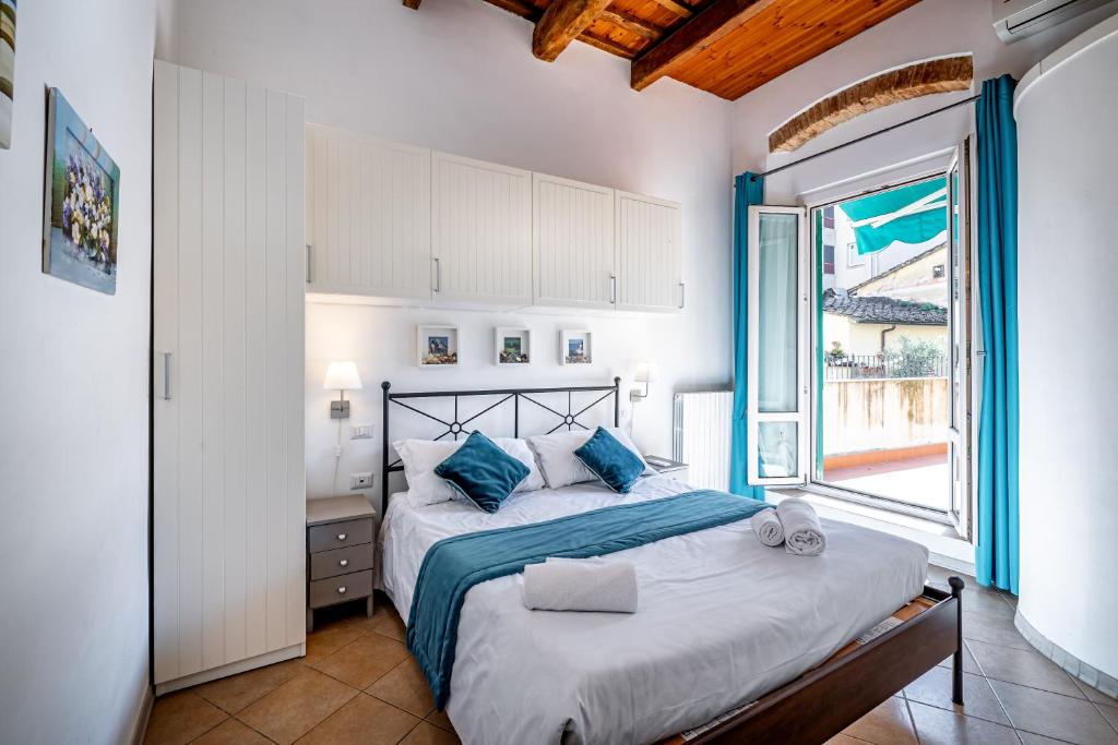 ein Schlafzimmer mit einem Bett und einem großen Fenster in der Unterkunft Roommo Beccaria in Florenz