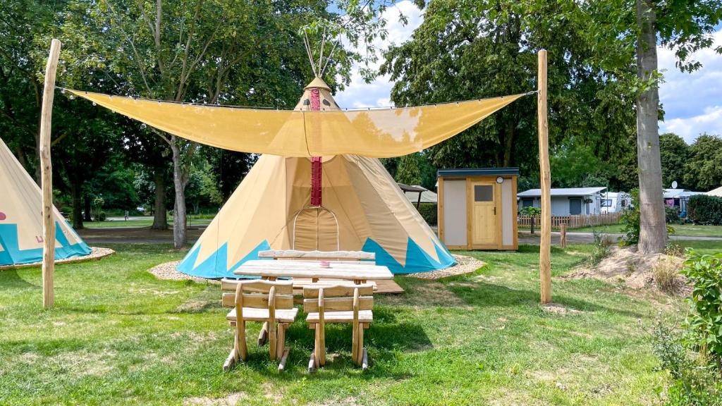 a play tent in a park with chairs in the grass at Tipi Ottawa in Falkenberg