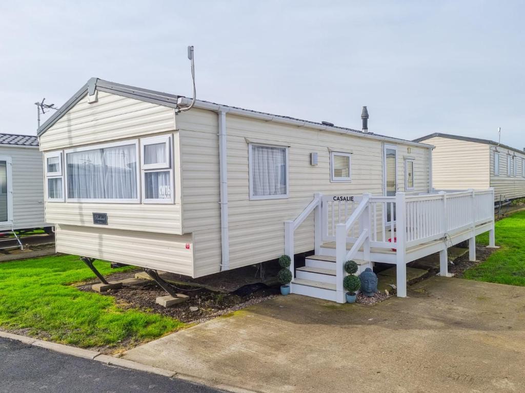 a white tiny house with a staircase in a yard at CASALIE at Seasalter Whitstable in Seasalter