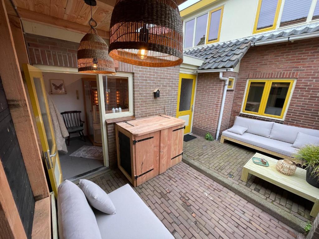 an outdoor patio with a kitchen and a couch at KUST4 huis met Sauna in Egmond aan Zee