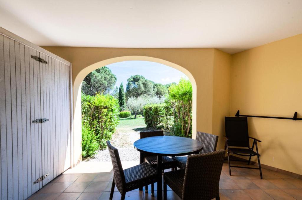 ein Esszimmer mit einem Tisch, Stühlen und einem Torbogen in der Unterkunft Village Pont Royal en Provence - maeva Home - Studio 5 personnes - Sélectio 824 in Mallemort