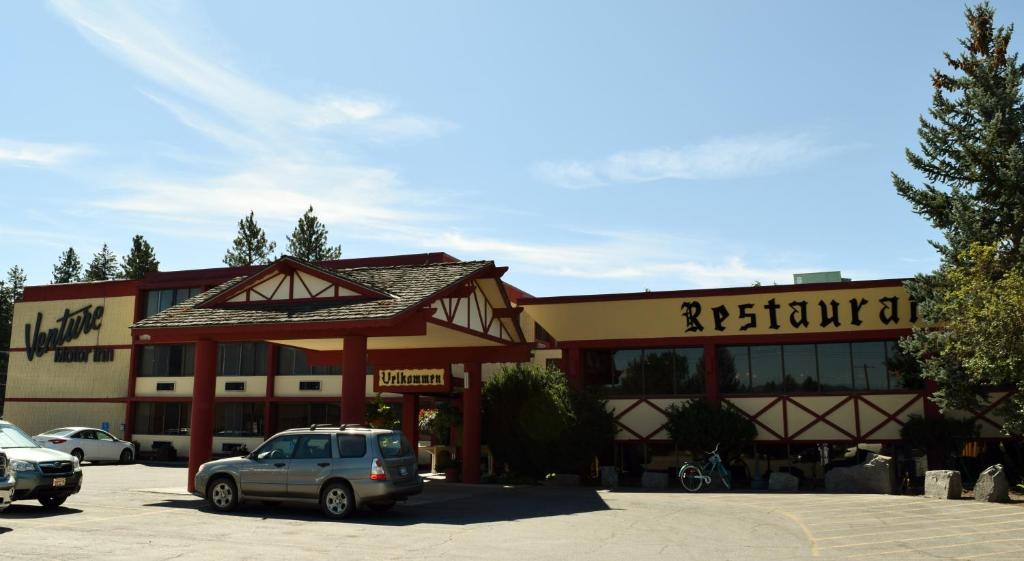 a building with a car parked in a parking lot at Venture Inn in Libby