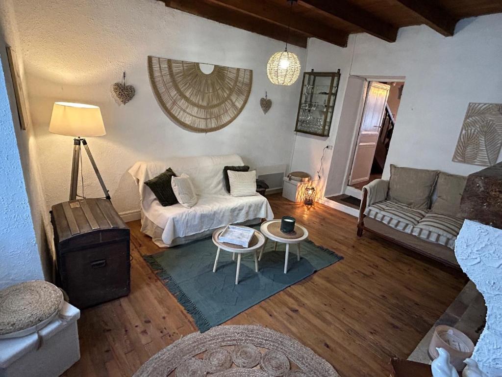salon z kanapą i stołem w obiekcie Maison dans la magnifique village de Montjoi w mieście Monjoi
