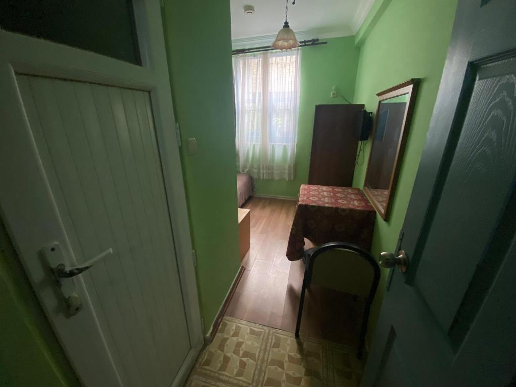 Cette chambre est dotée de murs verts, d'une porte et d'une table. dans l'établissement Camel Hotel & Apart, à Antalya