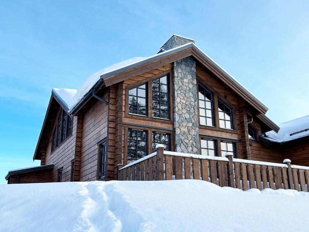 Ein Baumhaus im Schnee mit einem Zaun in der Unterkunft Fantastic Mountain Cabin with Sauna in Idre in Idre