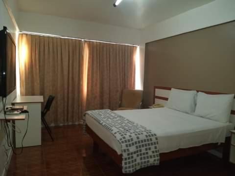 pokój hotelowy z łóżkiem i telewizorem w obiekcie Hotel Manaós w mieście Manaus