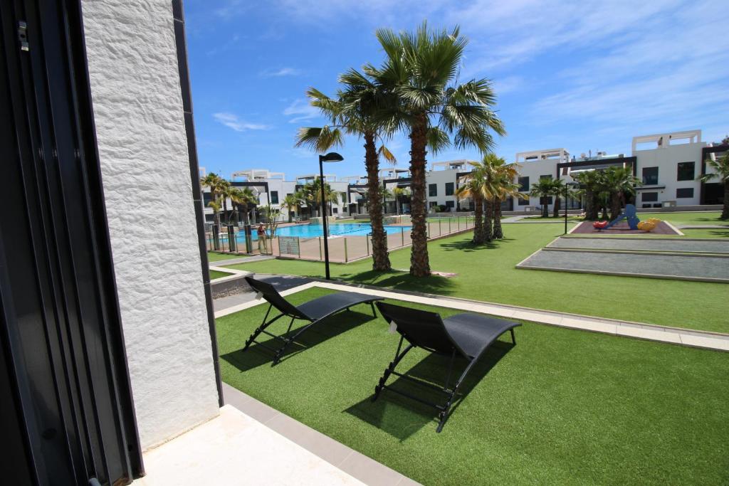 a balcony with a table and chairs and palm trees at La Zenia in Playas de Orihuela
