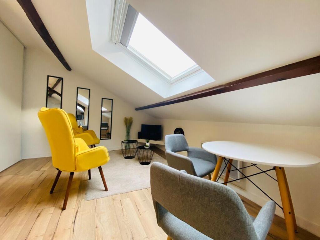 un salon avec des chaises jaunes et une table dans l'établissement Casa Balzac – T2, à Angers