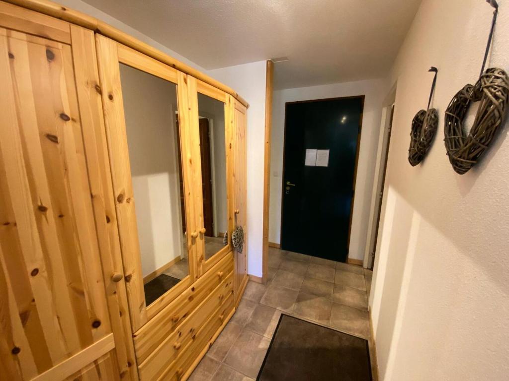 a hallway with a large wooden cabinet and a door at Résidence Plein Soleil - 2 Pièces pour 4 Personnes 004 in Montgenèvre