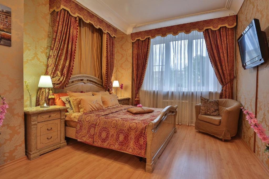 モスクワにあるLakshmi Apartment Boulevard 3-Bedroomのベッドルーム(ベッド1台、椅子、テレビ付)