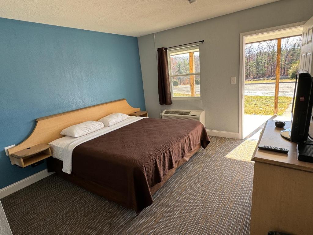 um quarto com uma cama com uma parede azul em Budget Inn em Thomasville