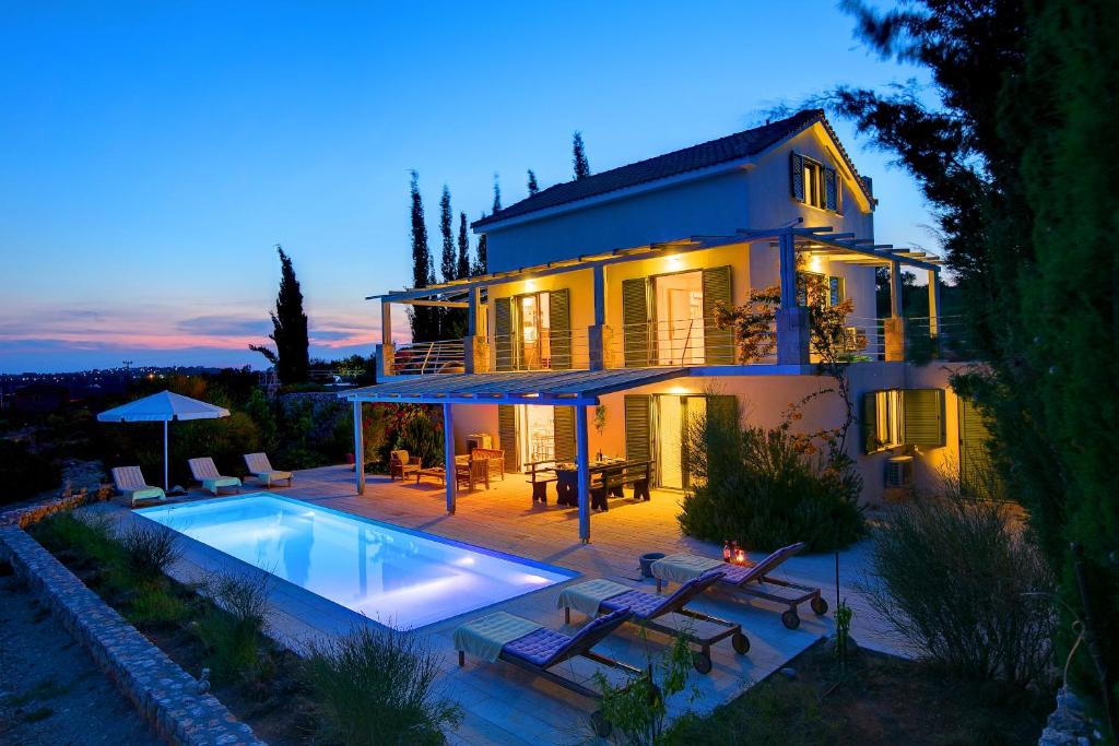 une maison avec une piscine en face de celle-ci dans l'établissement Villa Asterias Ideales Resort, à Céphalonie