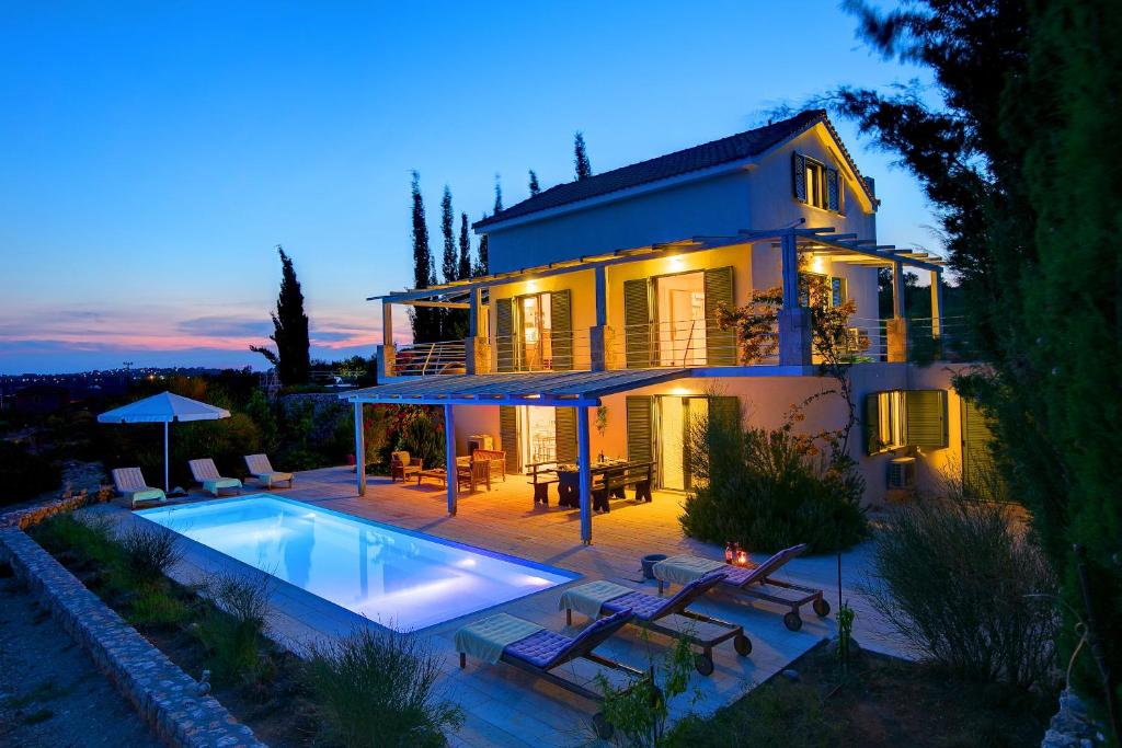 a house with a swimming pool in front of it at Villa Asterias Ideales Resort in Kefallonia