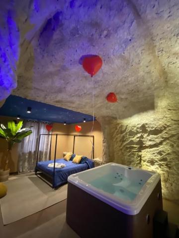 ein Schlafzimmer mit einem Bett und einer Badewanne in einem Zimmer mit einer Felswand in der Unterkunft suite 43 in Terrasini