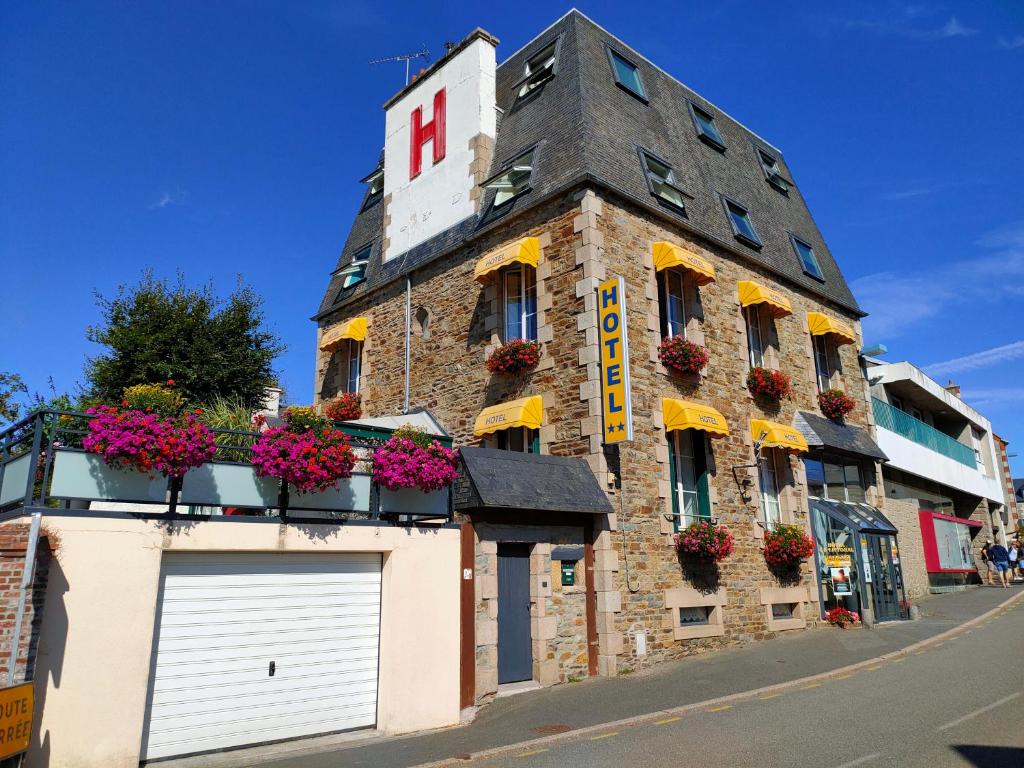 a building with flower boxes on the side of it at Hôtel le Littoral in Lézardrieux