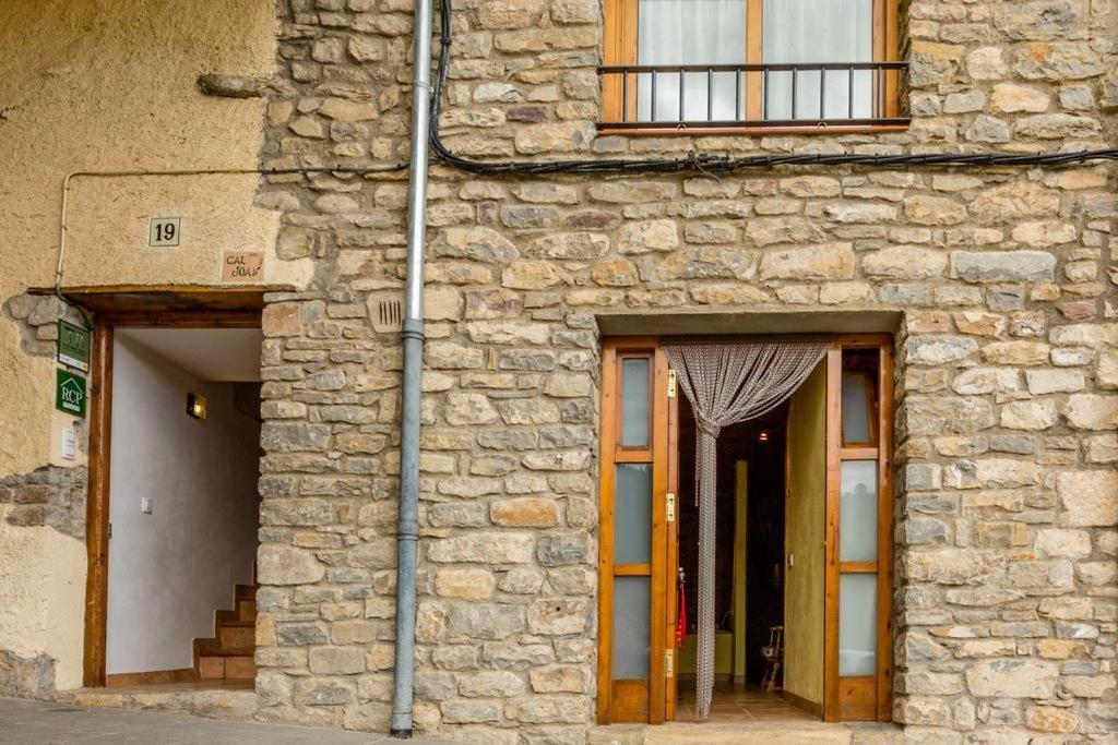 a stone building with two doors and a window at CAL JOAN pallars in Salás de Pallás
