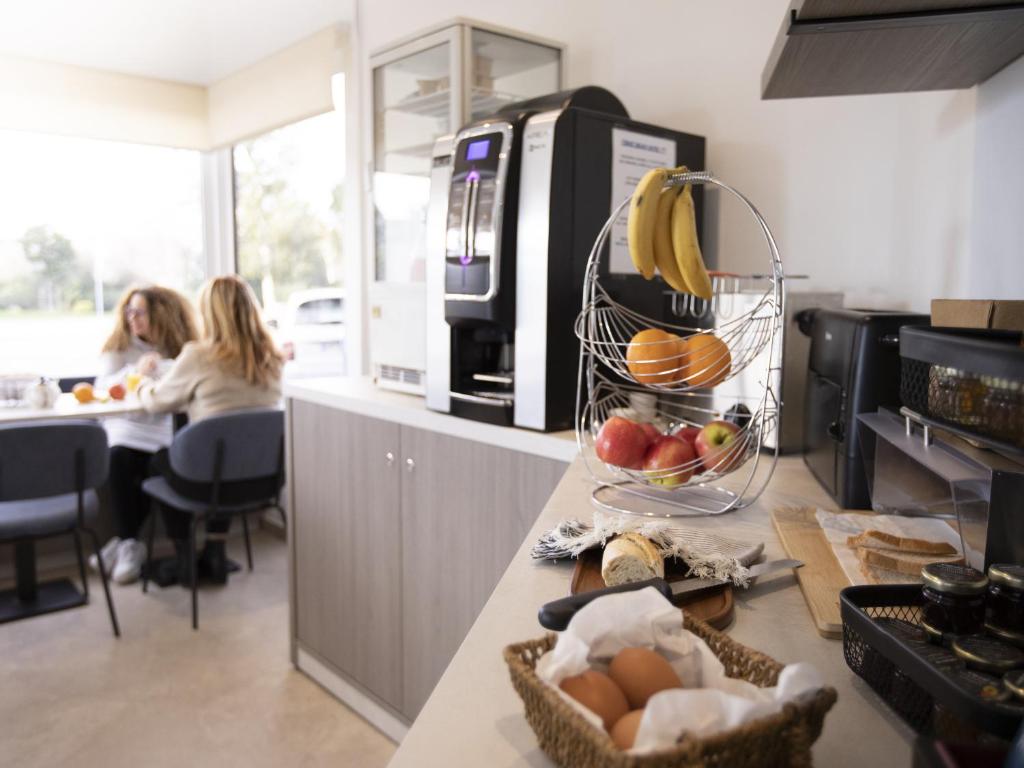 a kitchen with a counter with fruit in a basket at Tiercé Hotel in Cagnes-sur-Mer