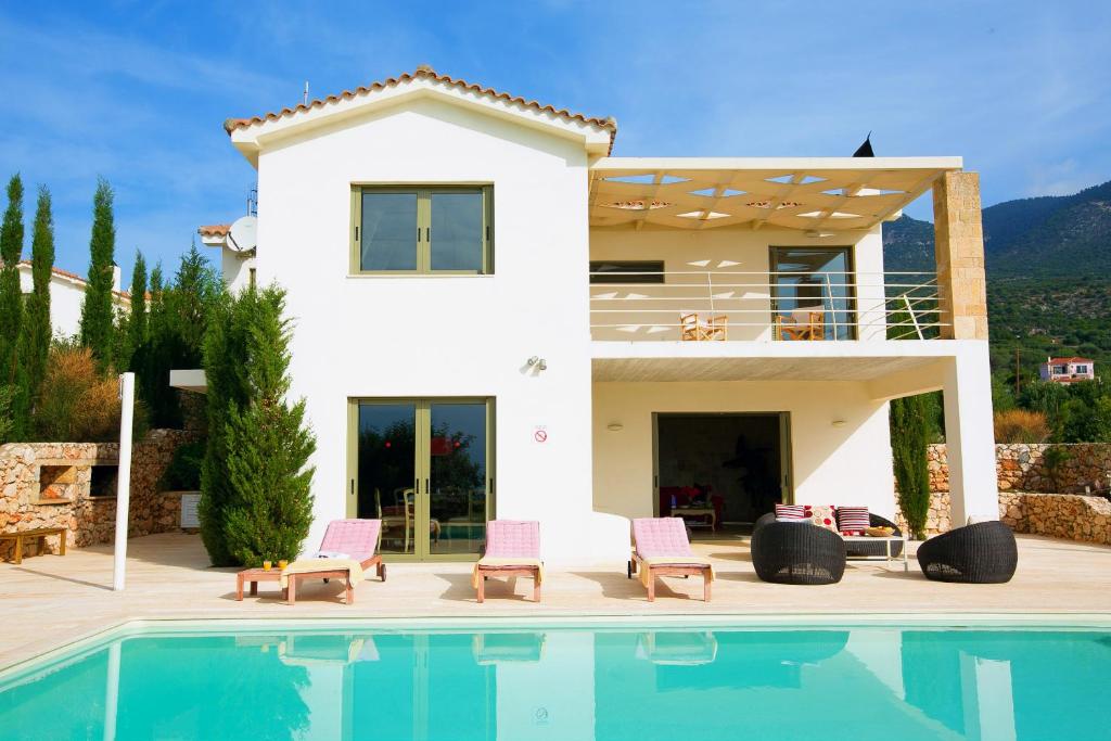 a villa with a swimming pool and a house at Villa Corali Ideales Resort in Kefallonia