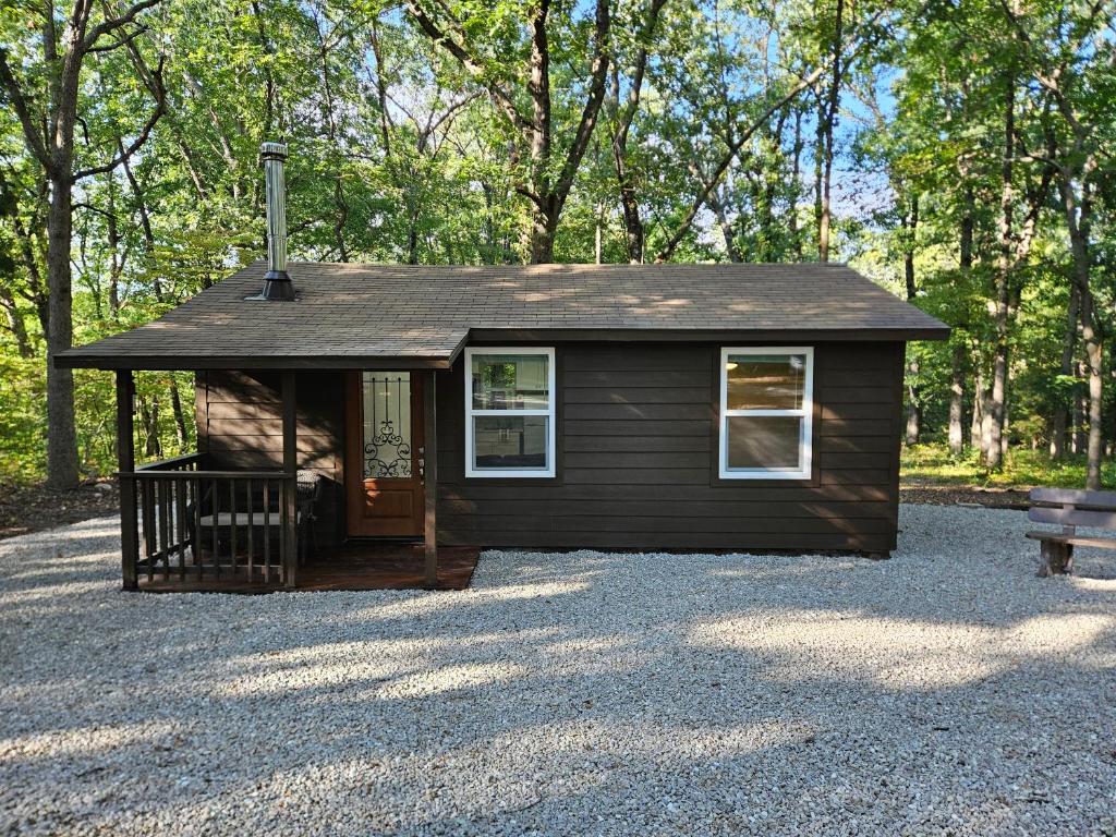 a small brown house with a bench in front of it at Bennettscape Tiny Cabin in Lebanon