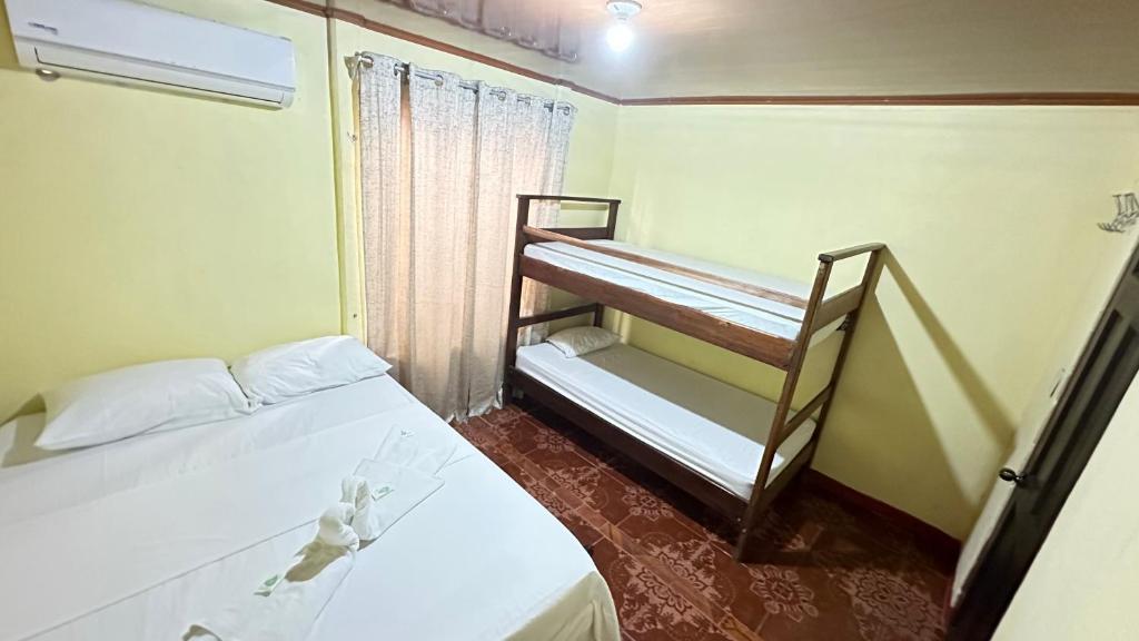 a small room with two bunk beds in it at The Corner House in Tortuguero