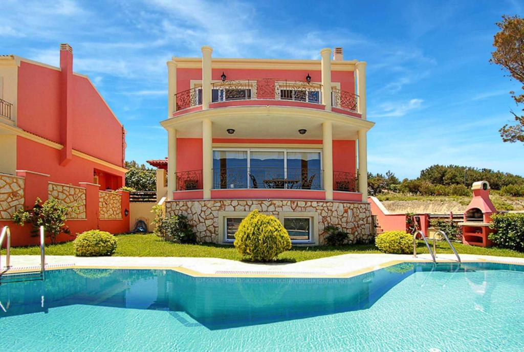 una casa con piscina frente a ella en Villa Romanza Beta en Agios Stefanos