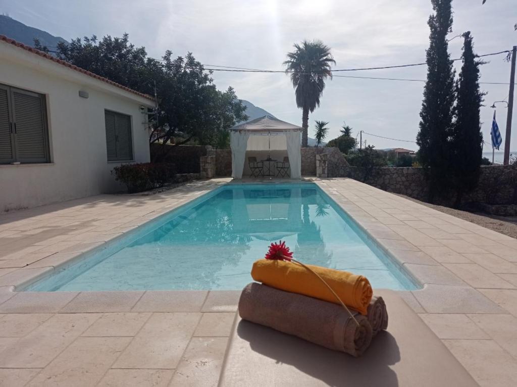 a swimming pool with a lifebuoy in front of a house at Villa Kochilaki Ideales Resort in Kefallonia