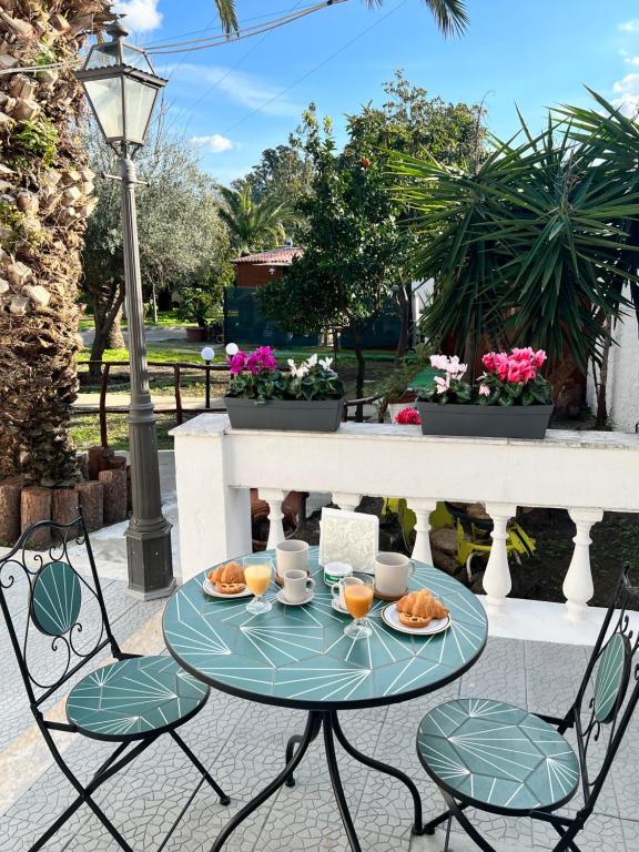 een tafel en stoelen met eten op een patio bij VesuvioSerenityRoom in Ercolano