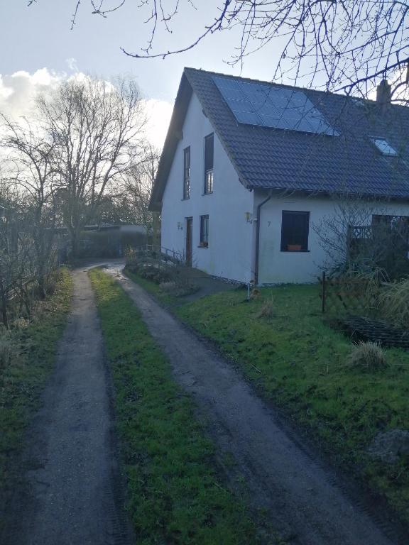 a white house with a dirt road in front of it at "Kleine Hedwig" in Putbus