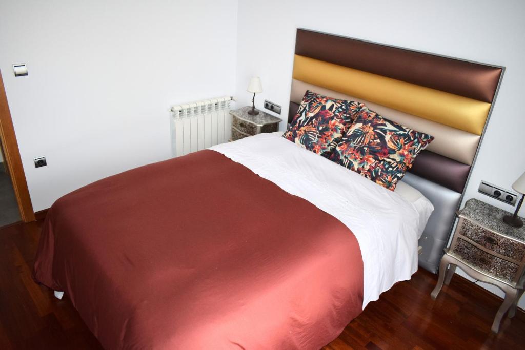 een slaapkamer met een groot bed met een rode en witte deken bij Alojamientos Yecla Centro by Casa de la Feria del Mueble Yecla in Yecla