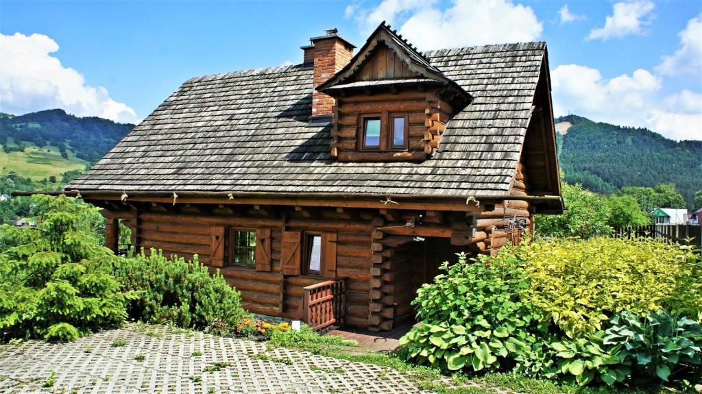 a log cabin in the middle of a garden at Dom z Widokiem in Piwniczna-Zdrój