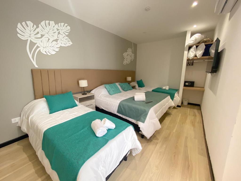 twee bedden in een kamer met groen en wit bij Hotel Caseros Salta in Salta