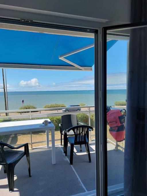 un balcon avec une table et des chaises et l'océan dans l'établissement F3 Face à Cordouan, à Saint-Palais-sur-Mer