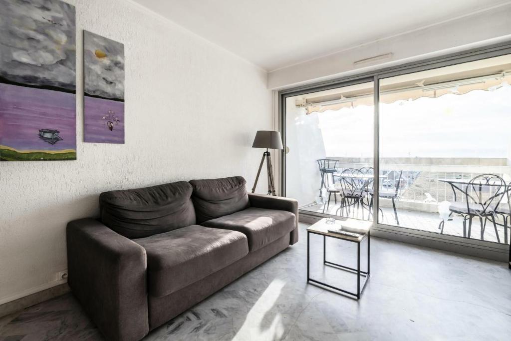 uma sala de estar com um sofá e uma grande janela em Le Saint Clair - maeva Home - Appartement 3 pièces 6 personnes - Prestige 004 em La Grande-Motte